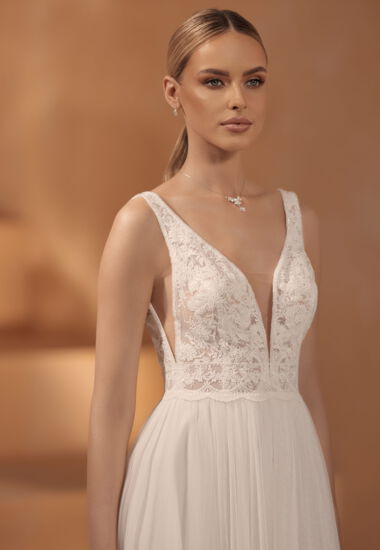 Dieses wunderschöne Brautkleid kombiniert Vintage- und Boho-Elemente und hat einen tiefen und sexy Ausschnitt.